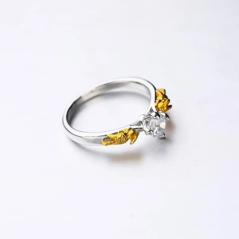 Copper crown design crystal ring in black gold finish on a size chart.