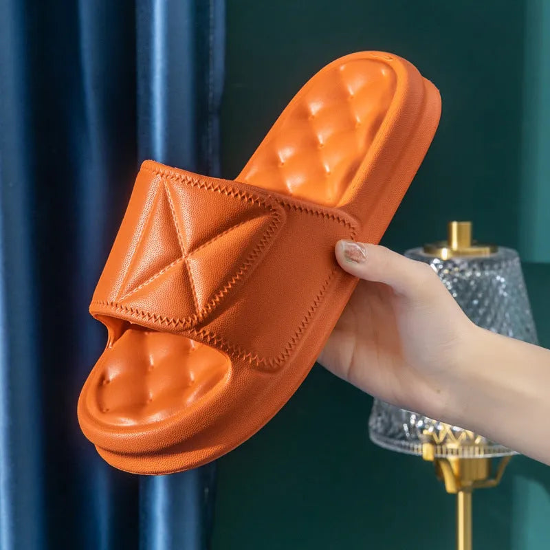 A pair of solid-colour EVA bathroom slippers with a thick, textured sole, shown on a bathroom floor.