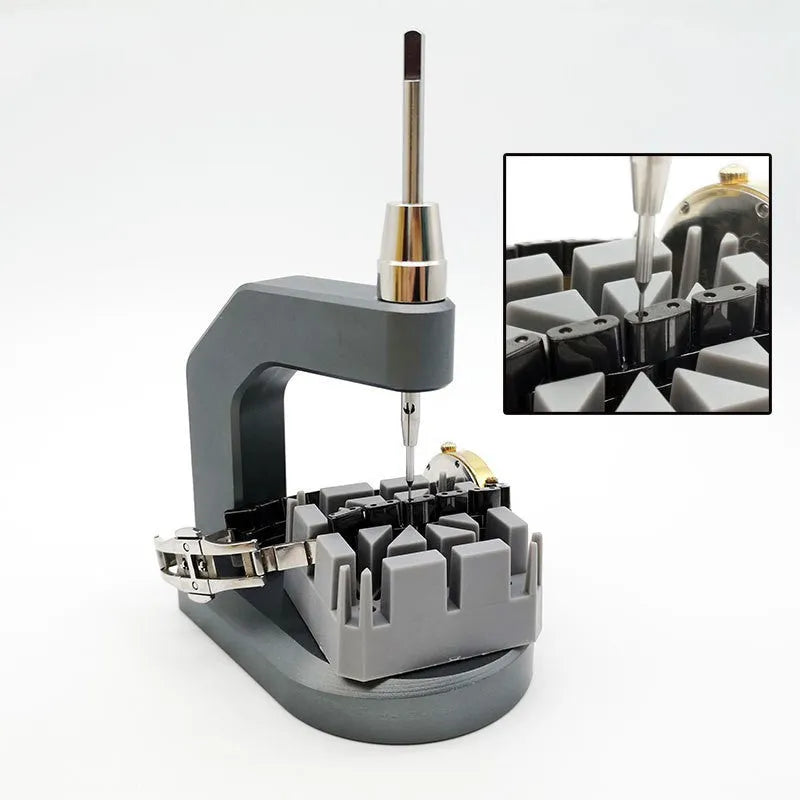Silver tool steel press strap removal tool for watch bands and jewellery on a grey background.