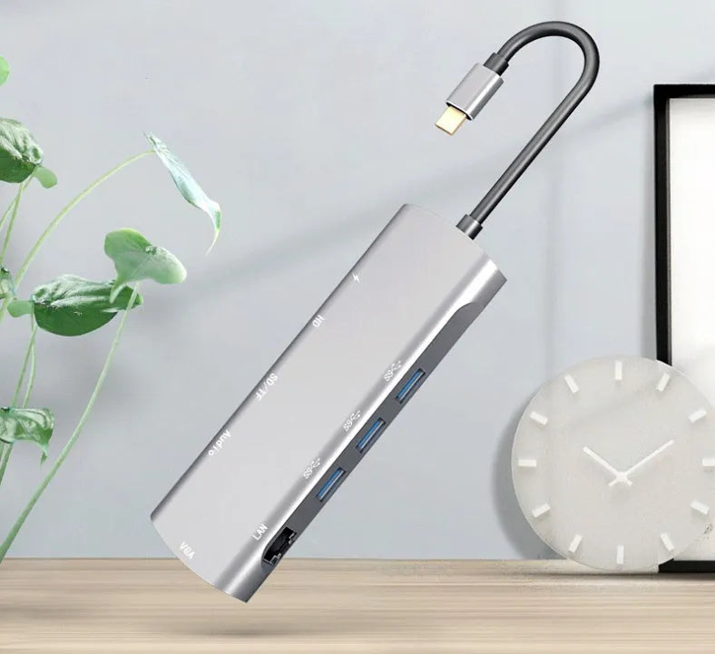 Grey aluminium USB-C docking station with HDMI, VGA, USB 3.0, and USB-C PD charging ports.
