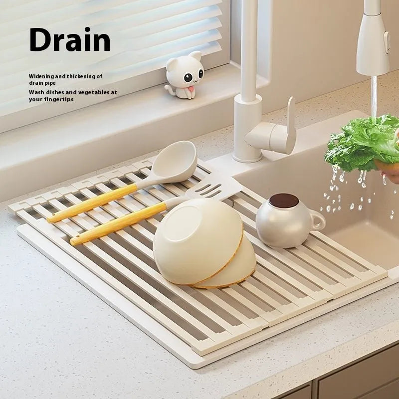 Foldable milky white stainless steel kitchen draining rack shown next to a sink.