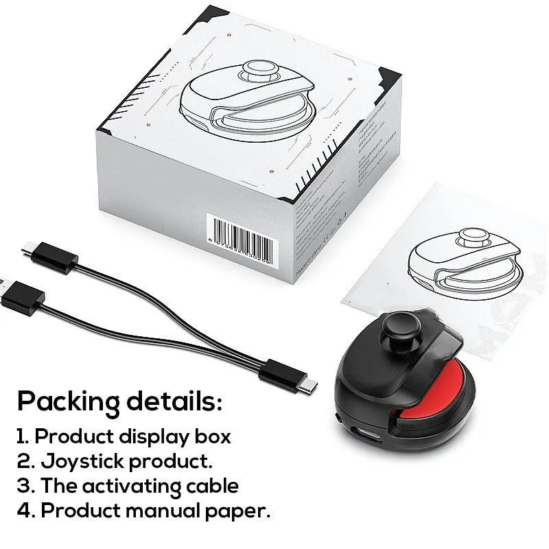 Black USB gaming stick controller on a desk next to a mobile phone