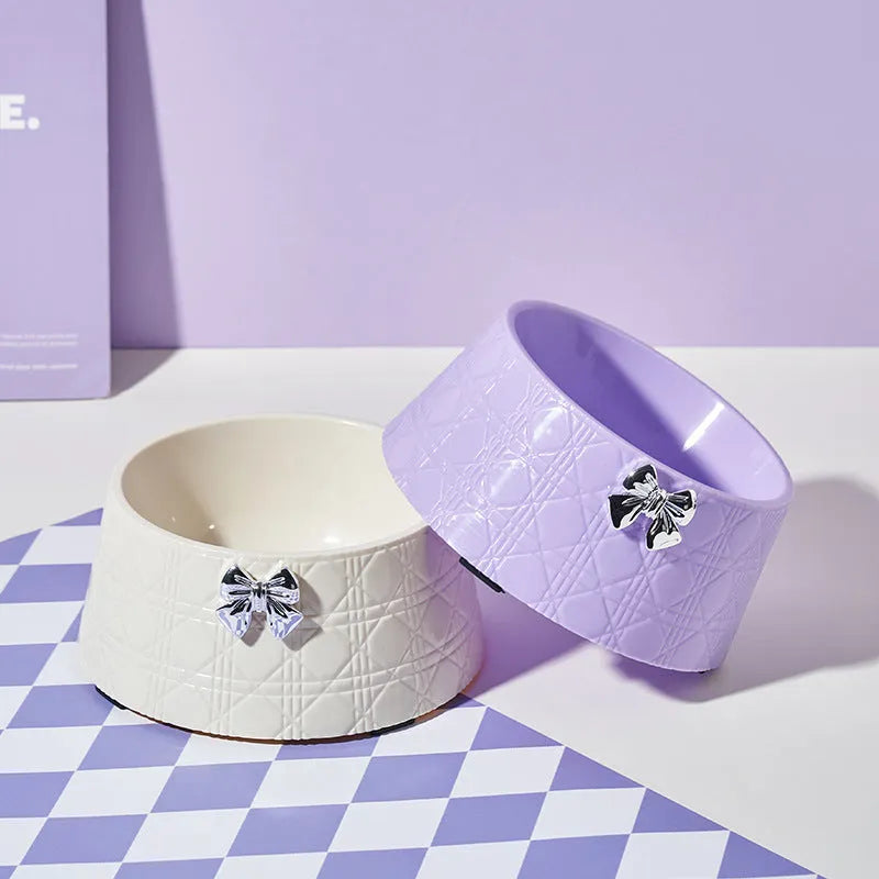Set of four pet food bowls with bowknot design and diamond pattern in pink, silver, black, purple, and white colours.