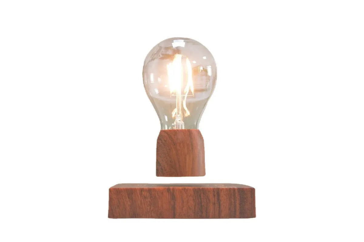 Magnetic levitation light bulb floating above wood-effect base with international plug adapters