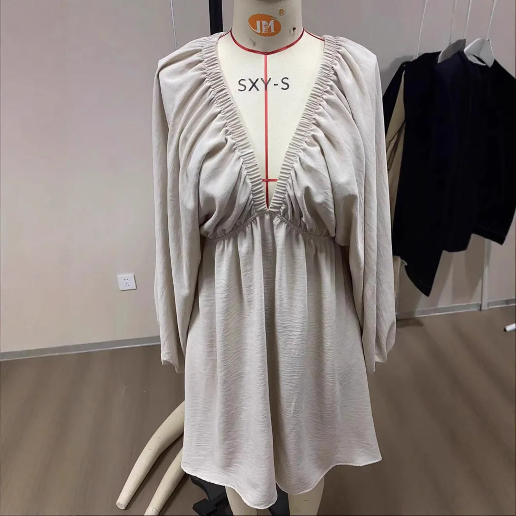 Women's apricot V-neck long-sleeve dress with puff sleeves and a flounce swing skirt on a hanger.