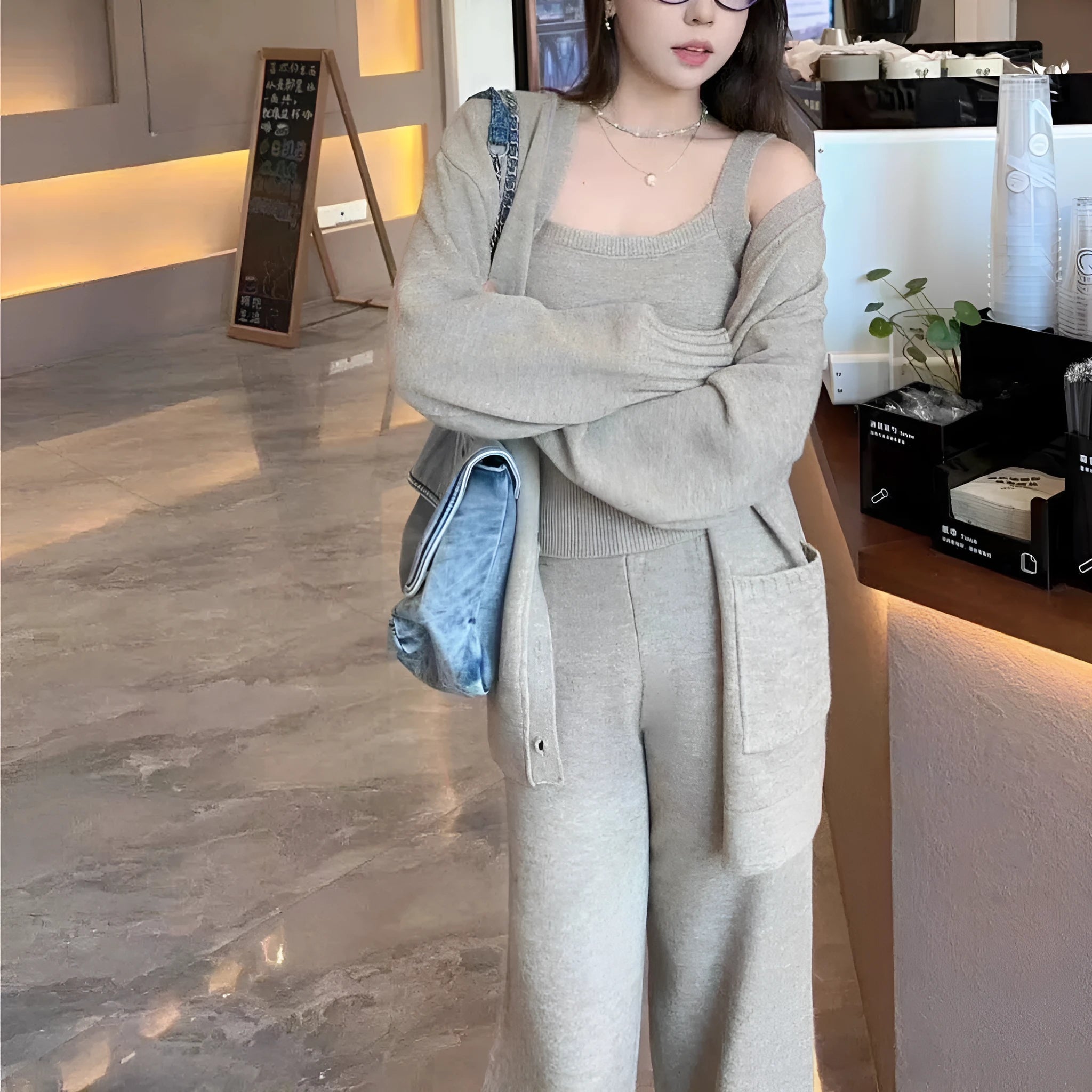 Women's light brown knit cardigan vest and trousers three-piece set laid flat.