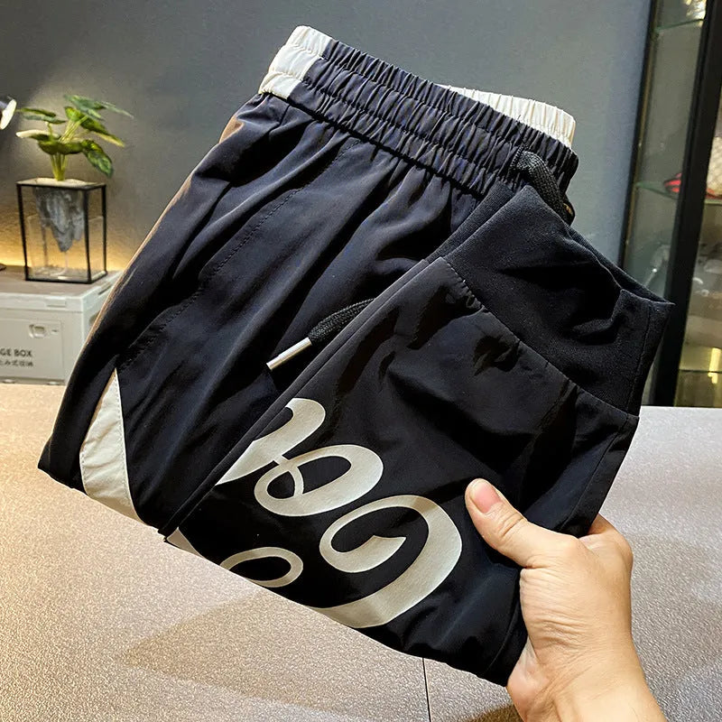 Man wearing solid black cropped cotton trousers with an ankle band.