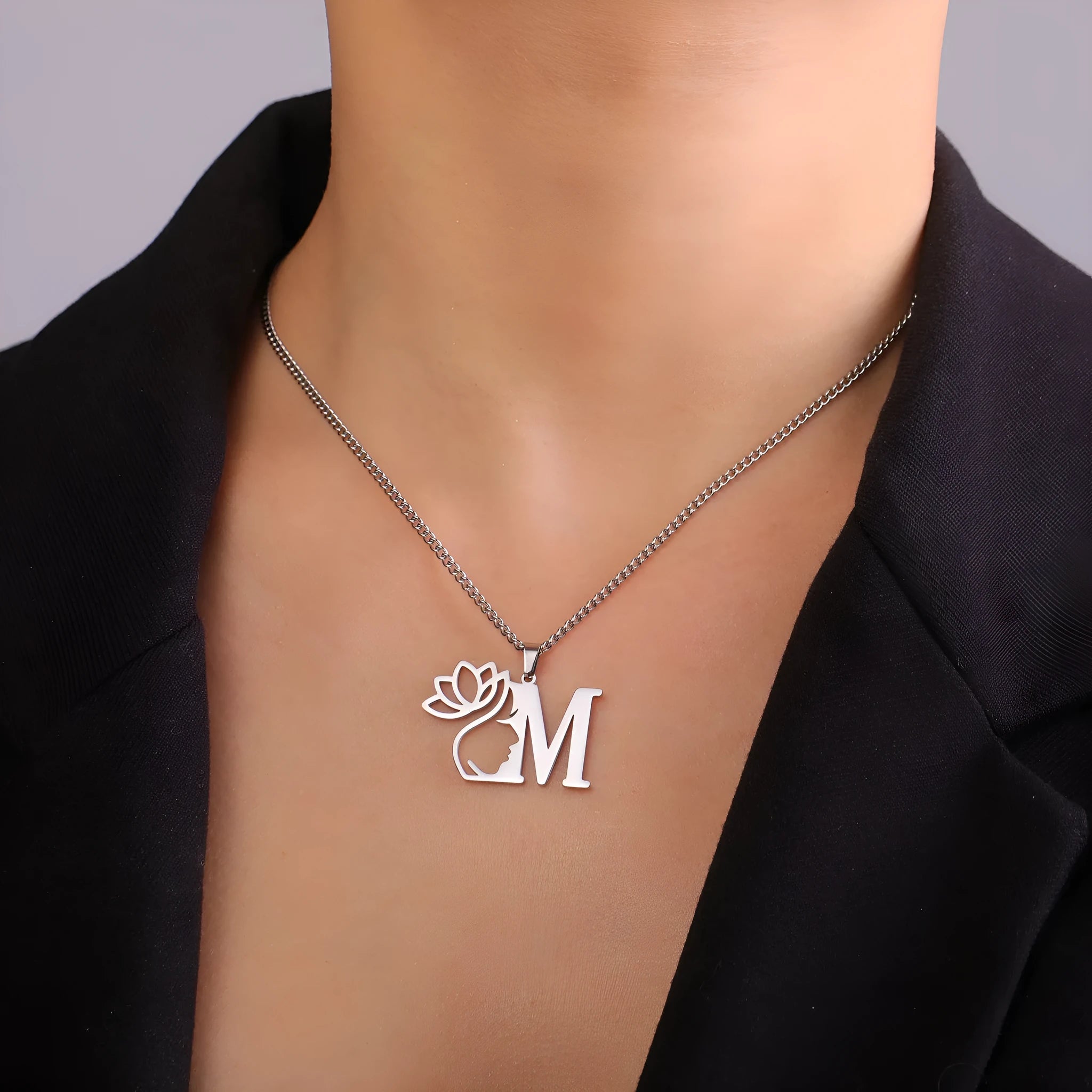 Stainless steel letter necklace with cross chain and gold electroplated pendant.