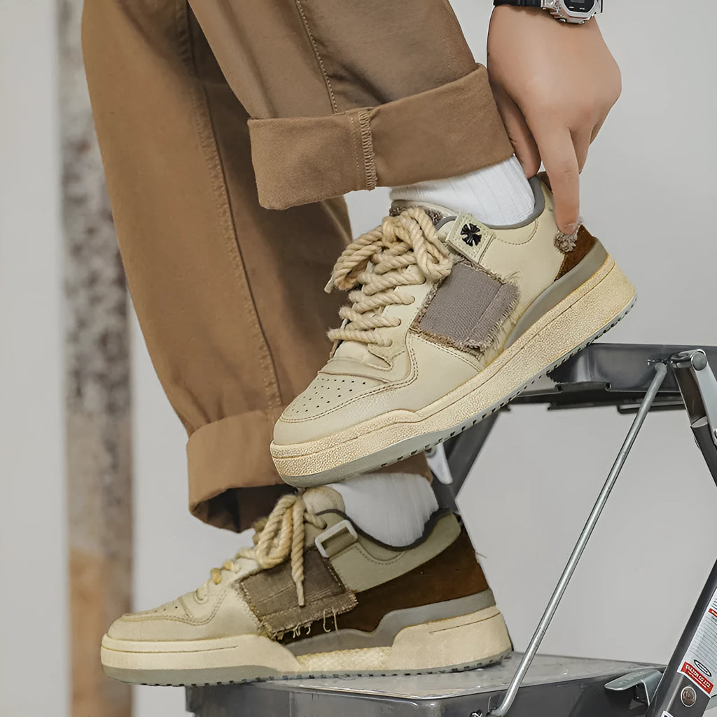 Beige low-top vintage skate shoes with round toe and front lace-up closure on a solid background.