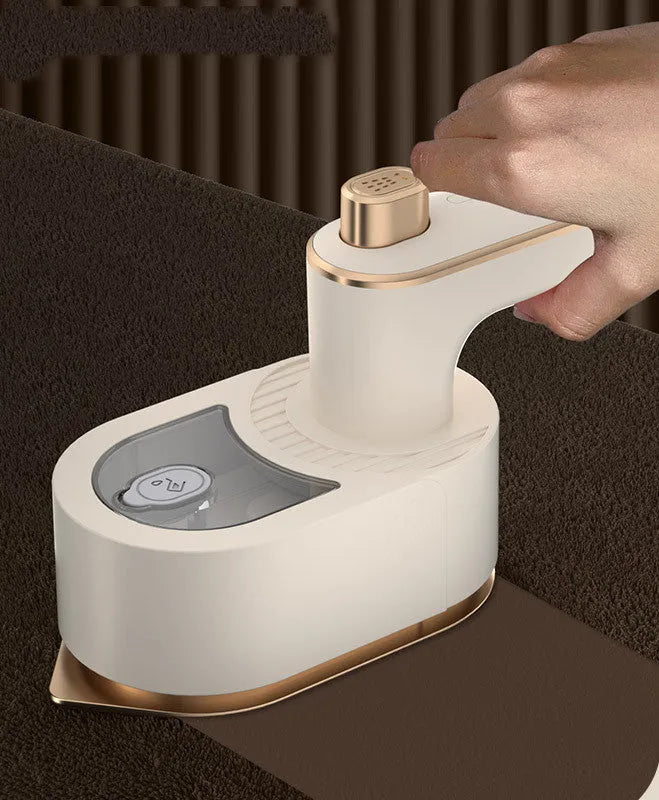 Folding handheld garment steamer in beige with compact design for travel