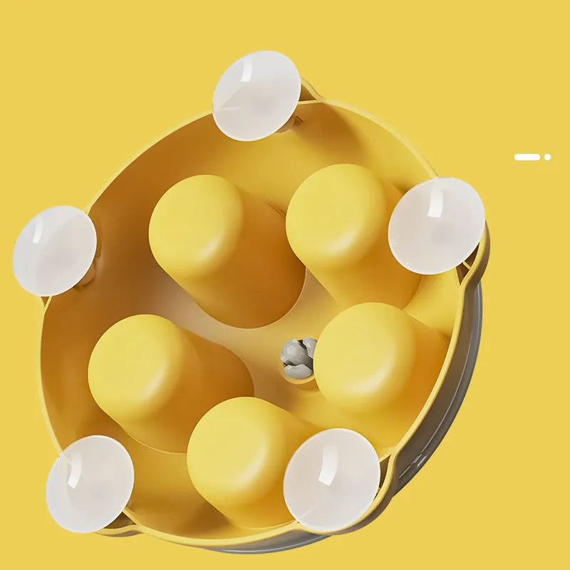 Yellow plastic cat puzzle feeder plate with four rotating balls for slow feeding.