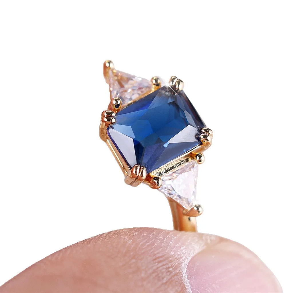 A rectangular copper fashion ring for women with a gold sapphire blue finish.