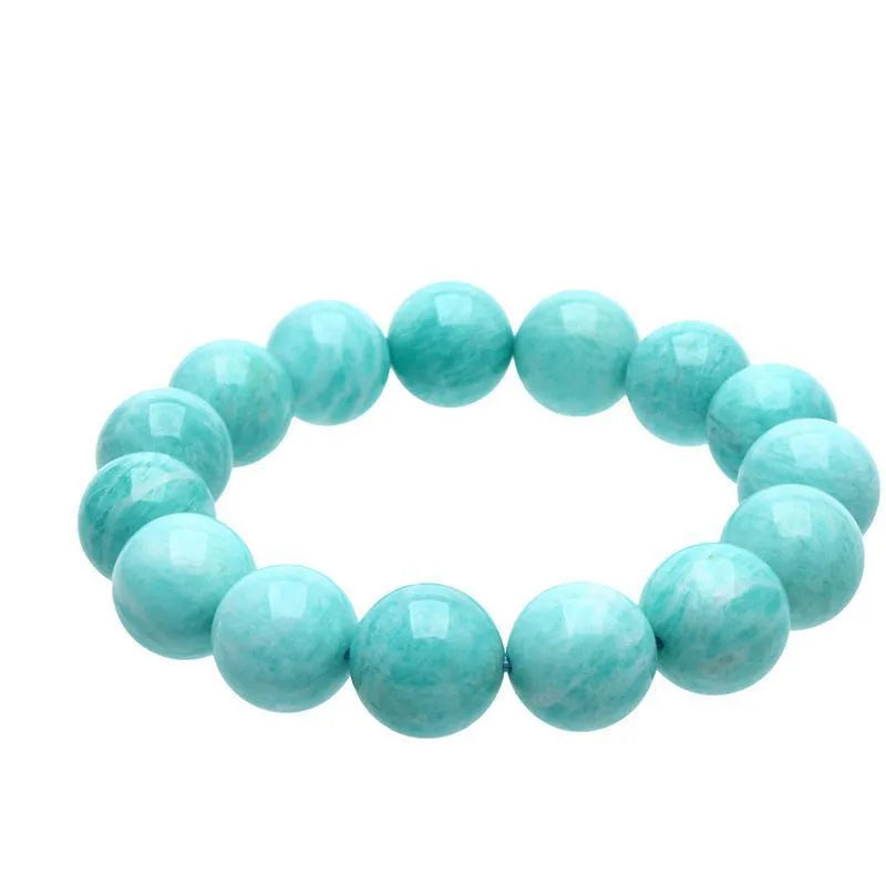 A single green amazonite bead bracelet on an elastic cord, shown in a natural setting.