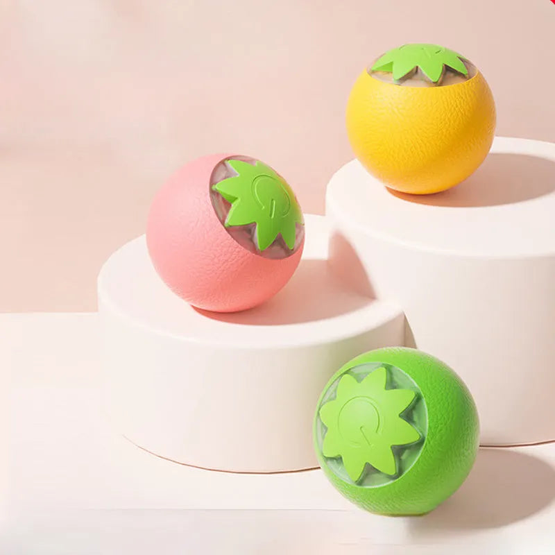 Small green automatic rolling ball toy for dogs and cats on a wooden floor.
