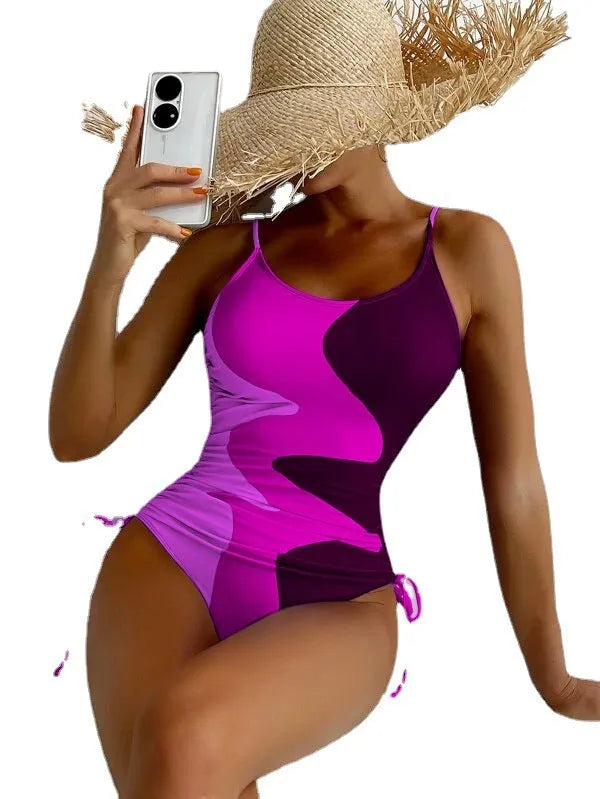 Women's sleeveless one-piece swimsuit in blue, shown from the front, with a backless design and striped pattern.