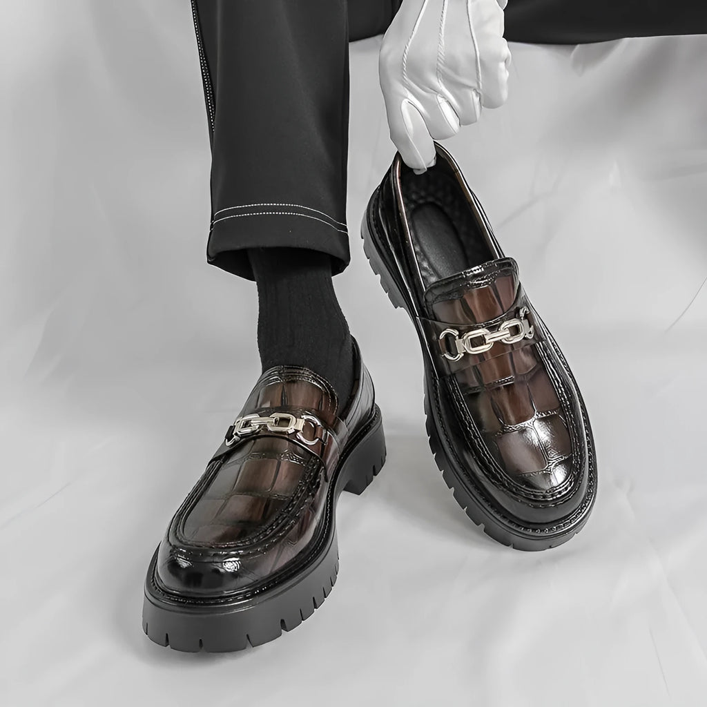 Men's black crocodile pattern leather loafers with a flat heel.