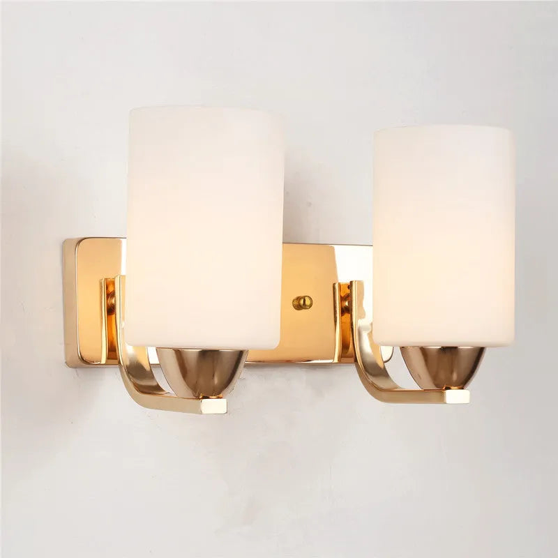 Chrome-plated wall lamp with clear glass shade mounted beside bed