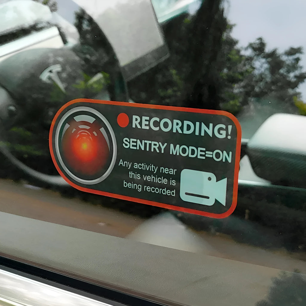 Pair of white rectangular Tesla Sentry Mode warning stickers with black text, 11cm by 5cm.