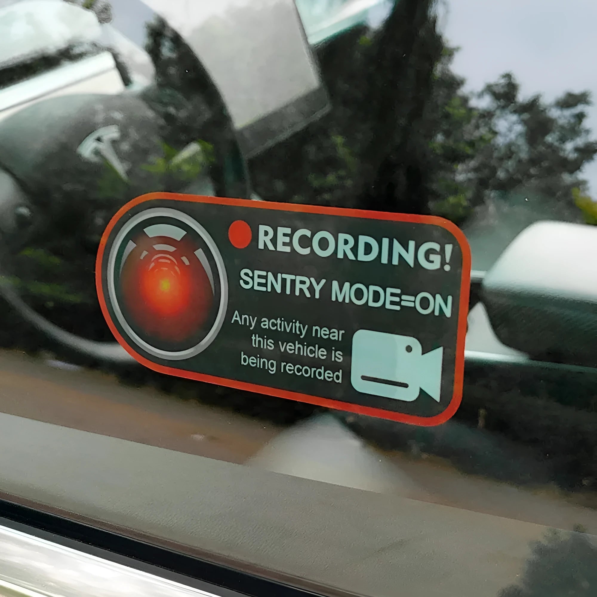 Pair of white rectangular Tesla Sentry Mode warning stickers with black text, 11cm by 5cm.