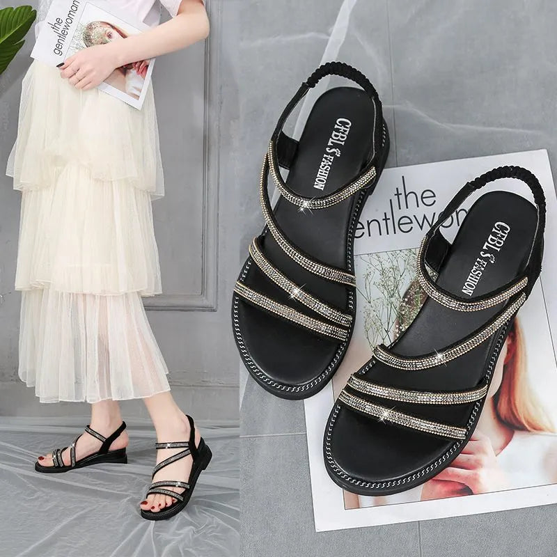 Gold women's flat sandals with rhinestone decoration and elastic band, on a rubber sole.