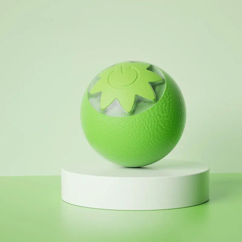 Small green automatic rolling ball toy for dogs and cats on a wooden floor.