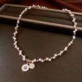 Gold electroplated necklace with round imitation pearl pendant featuring zircon details on adjustable clavicle chain