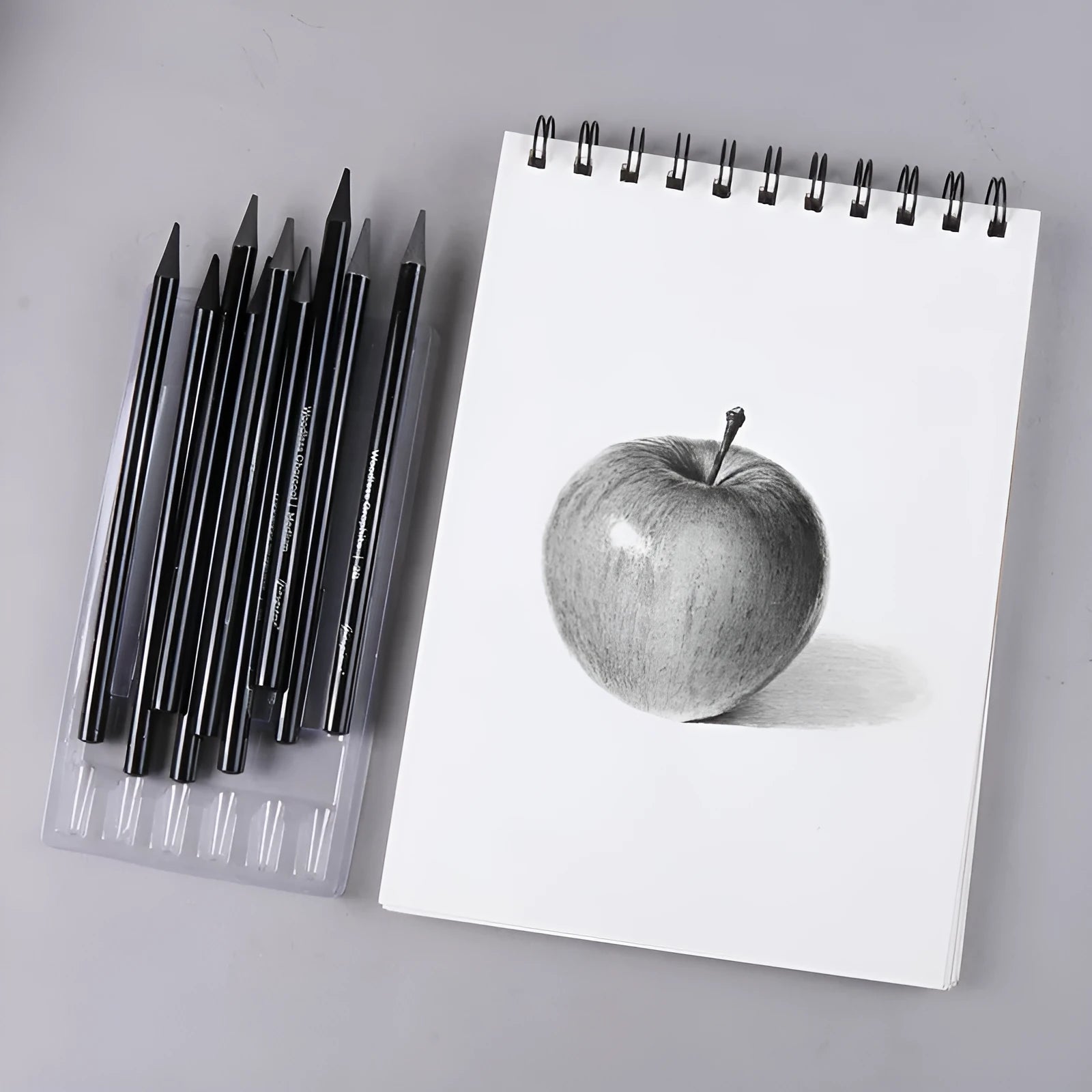 Set of six graphite pencils and three carbonized pencils with wooden shells on suction card packaging