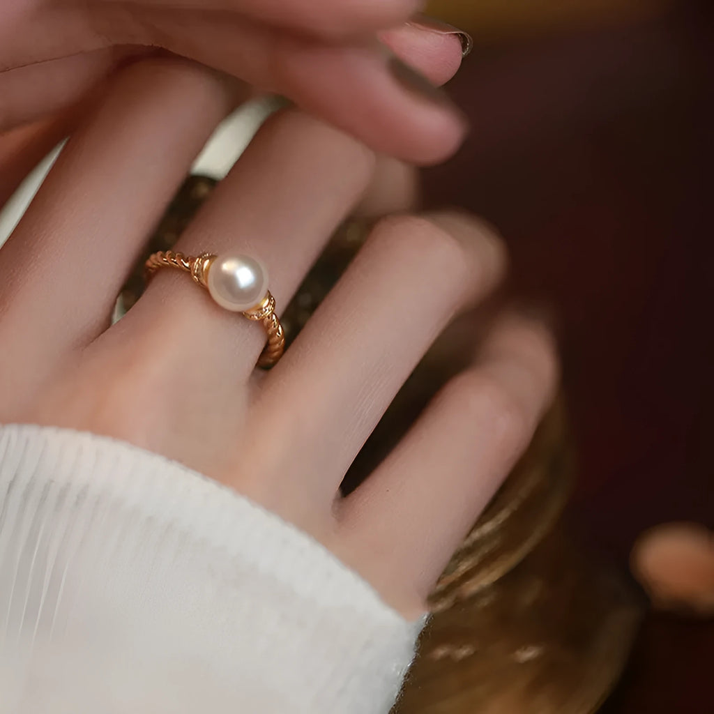 Adjustable antique twist copper ring with a central pearl inlay, shown in gold and silver tone finishes.