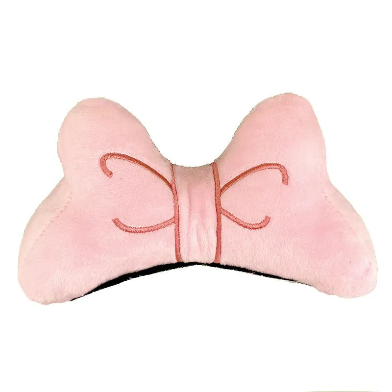 A soft red plush bow tie decoration for attaching to a motorcycle or ski helmet.