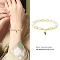 Natural Hetian jade and sterling silver bamboo leaf bracelet on a wrist, showing gold and silver finish options.