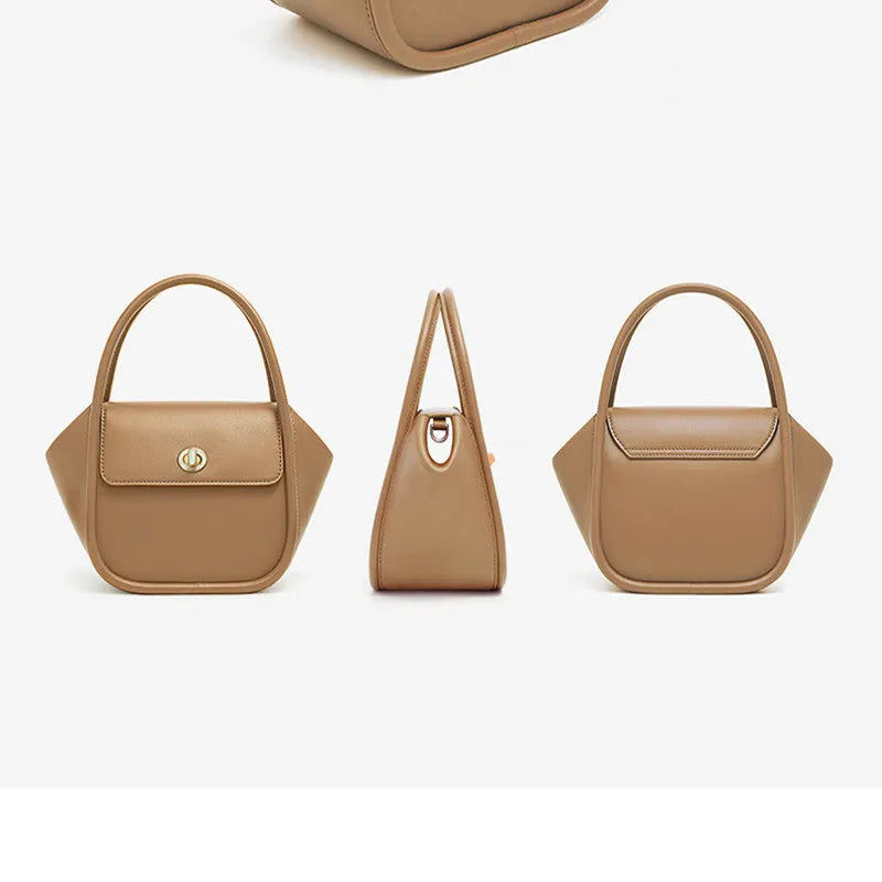 Women's wing-shaped leather tote bag with a latch buckle, shown in Atlantic blue with a cross-body strap.