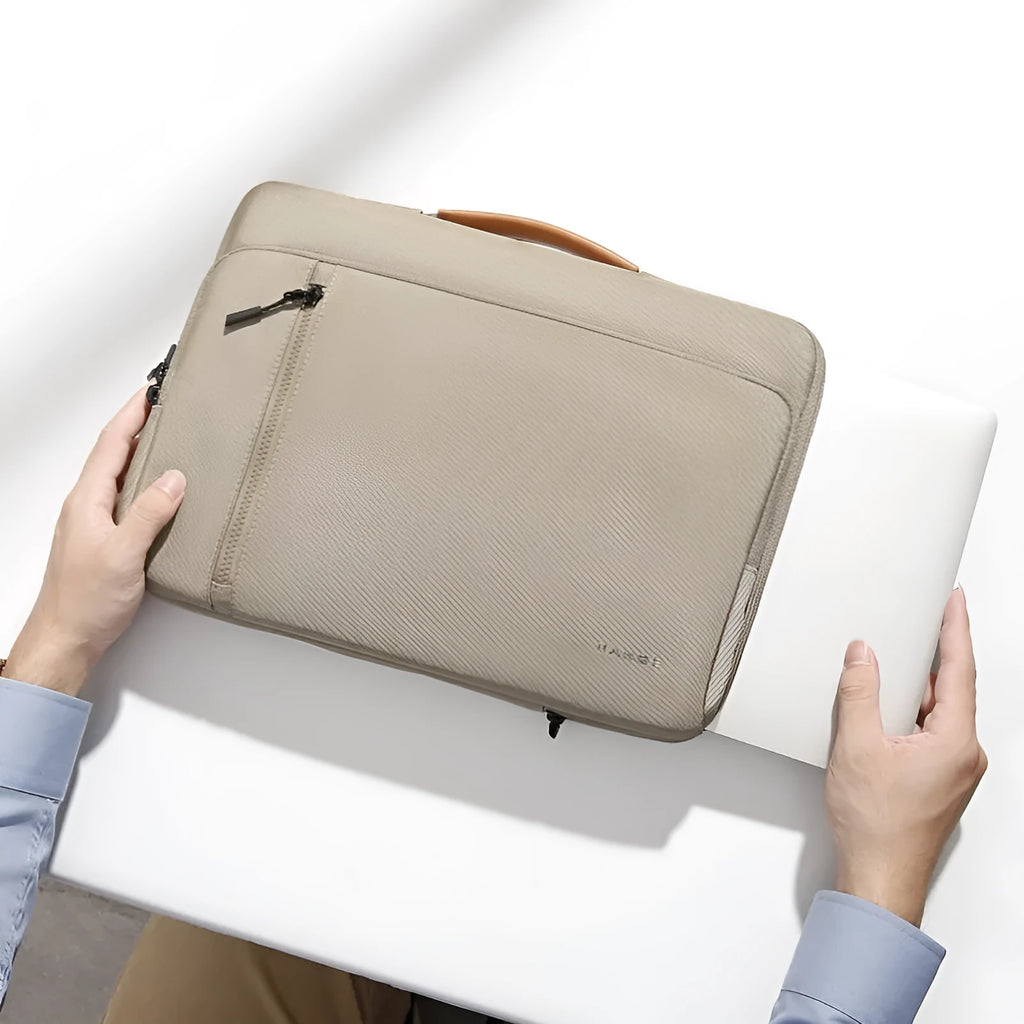 Khaki nylon laptop sleeve with zip closure and visible sewing lines next to a 14-inch notebook