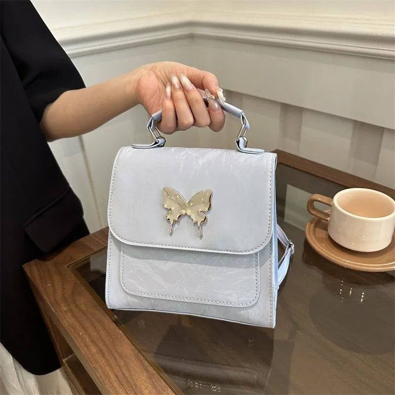 Women's preppy style hand-carry backpack in PU leather with bow detailing and mobile phone compartment