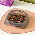 Blue plastic slow feeder dog bowl with raised internal maze pattern to prevent fast eating.