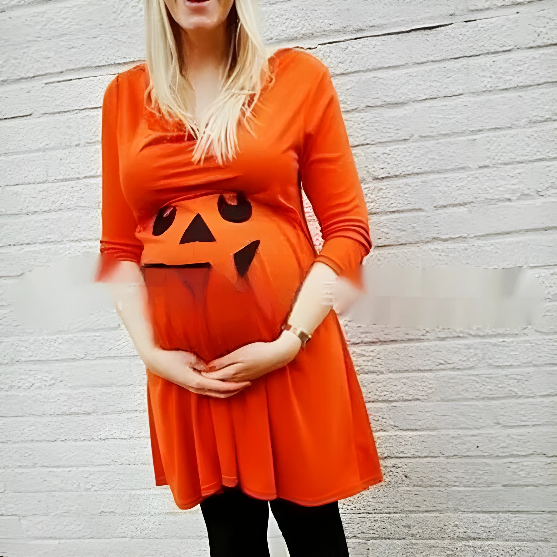 Orange cotton maternity dress for Halloween, shown on a hanger.