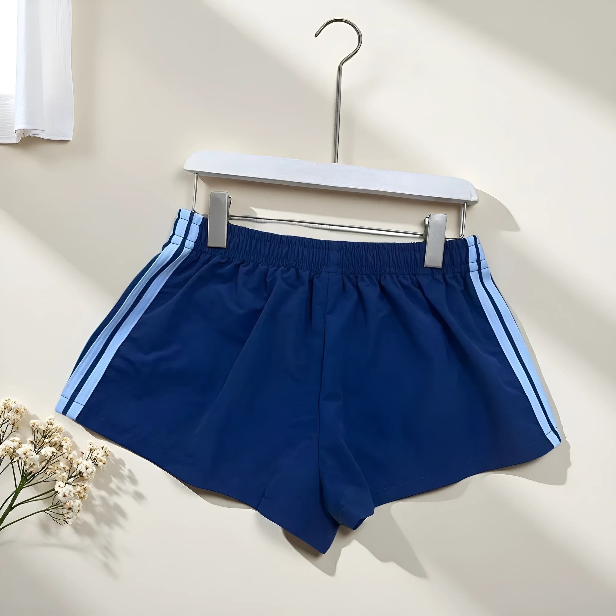 Men's navy blue high-waist nylon sports shorts laid flat, showing casual style and micro-elastic fabric.