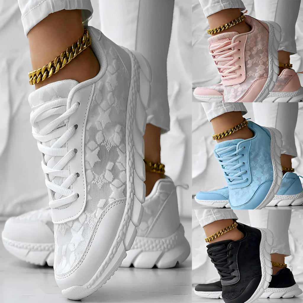 Women's white canvas sports running shoes with flat heel and round toe on a plain background.