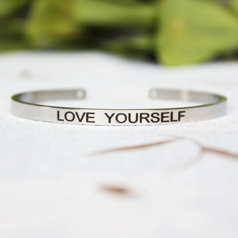 Silver customisable stainless steel bracelet with laser engraved text and adjustable fit on neutral background