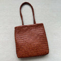 Brown woven leather tote bag with three-dimensional pocket and shoulder strap