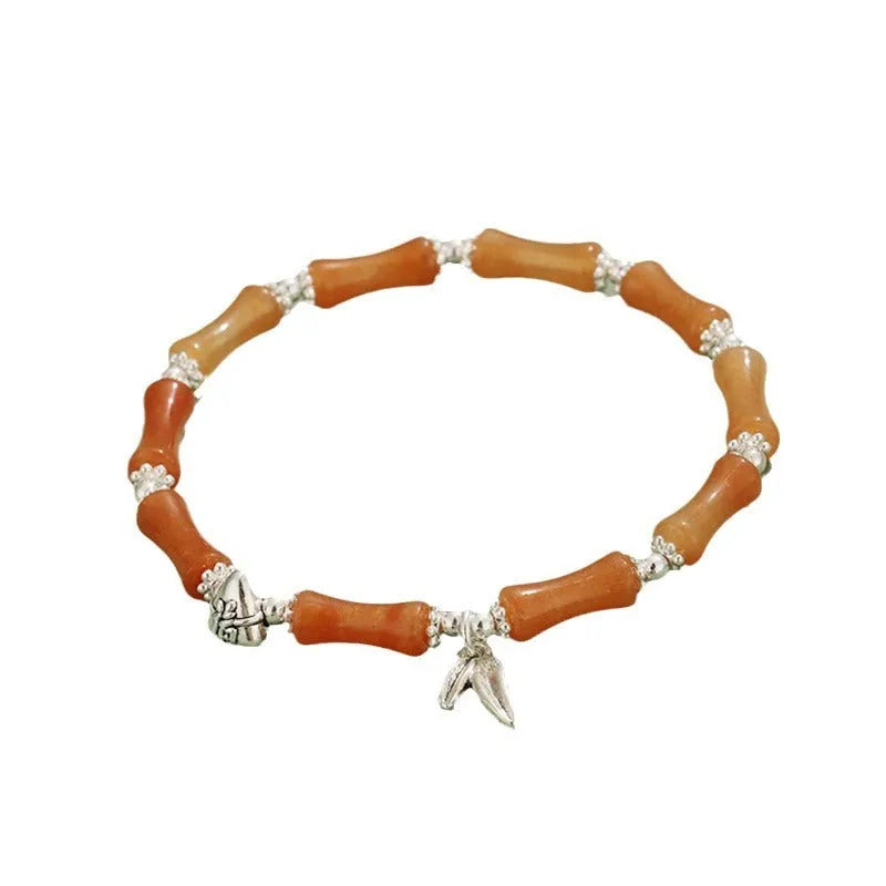 Green aventurine bamboo bead crystal bracelet with strawberry quartz and Dongling stones on wrist.
