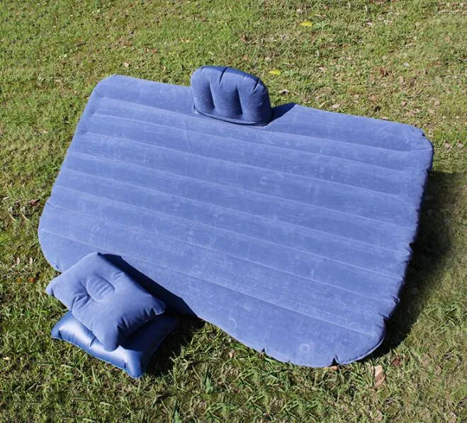 Black inflated car bed with flocked surface and two pillows inside a five-seater vehicle.
