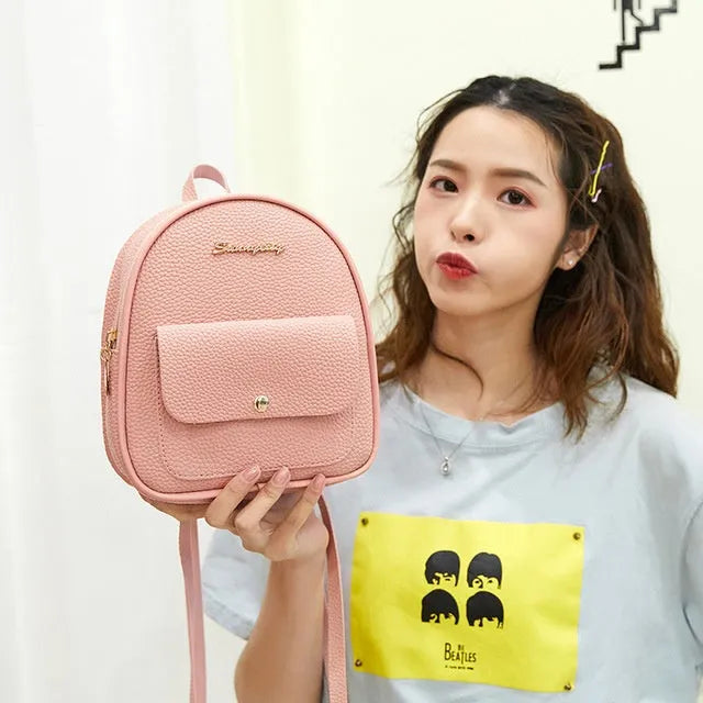 A compact black PU women's backpack purse with a zipper, shown as a small shoulder bag.