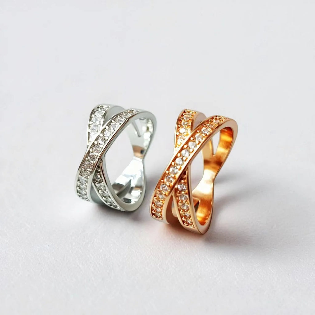 Silver and rose gold metal cross ring with micro-inlaid zircon stones in heart and geometric shapes.