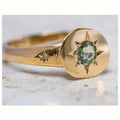 Gold-coloured adjustable ring with a central oval star-shaped zircon stone on a simple band.