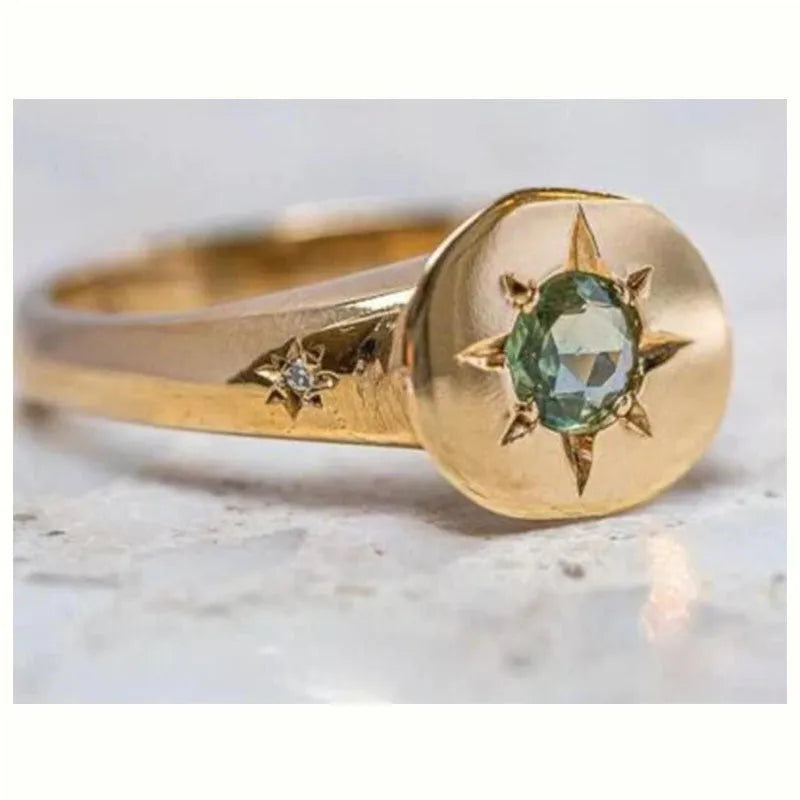 Gold-coloured adjustable ring with a central oval star-shaped zircon stone on a simple band.