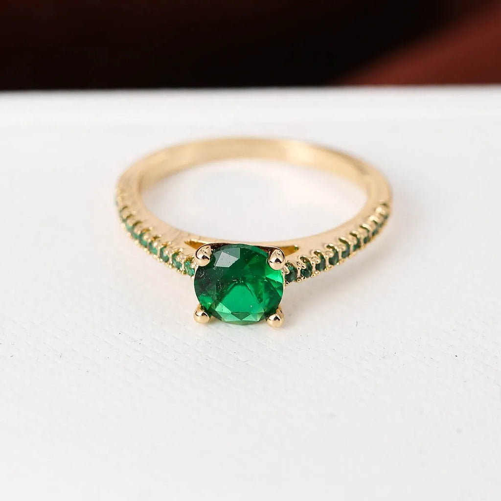 Geometric hexagonal copper ring with colourful zircon stones on a grey background.