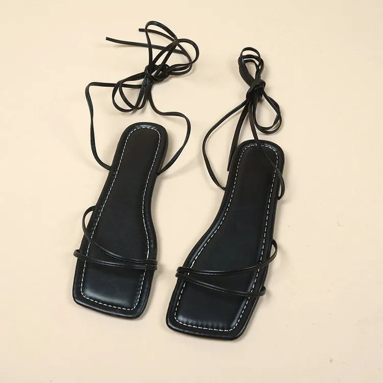 Women's flat sandals with an ankle ring bandage cloth strap and front lace-up fastening in orange.