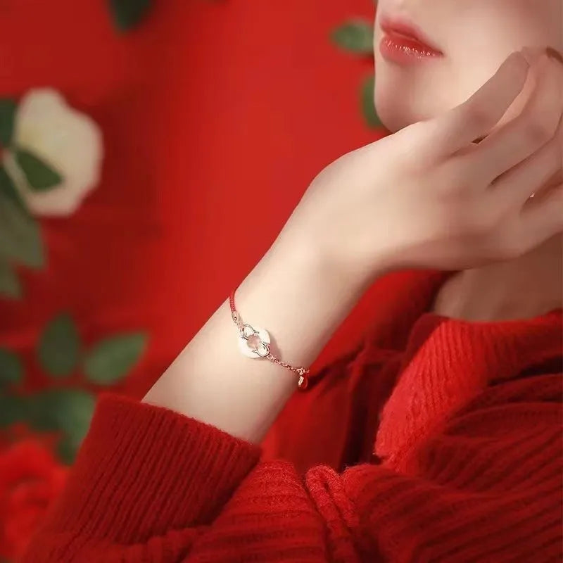 Festive koi bracelet with fishtail design and peace buckle closure on red rope