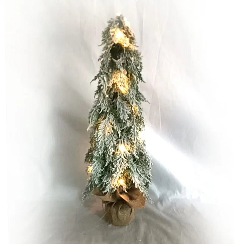 Small 24-inch white snow spray Christmas tree with integrated lights on desktop