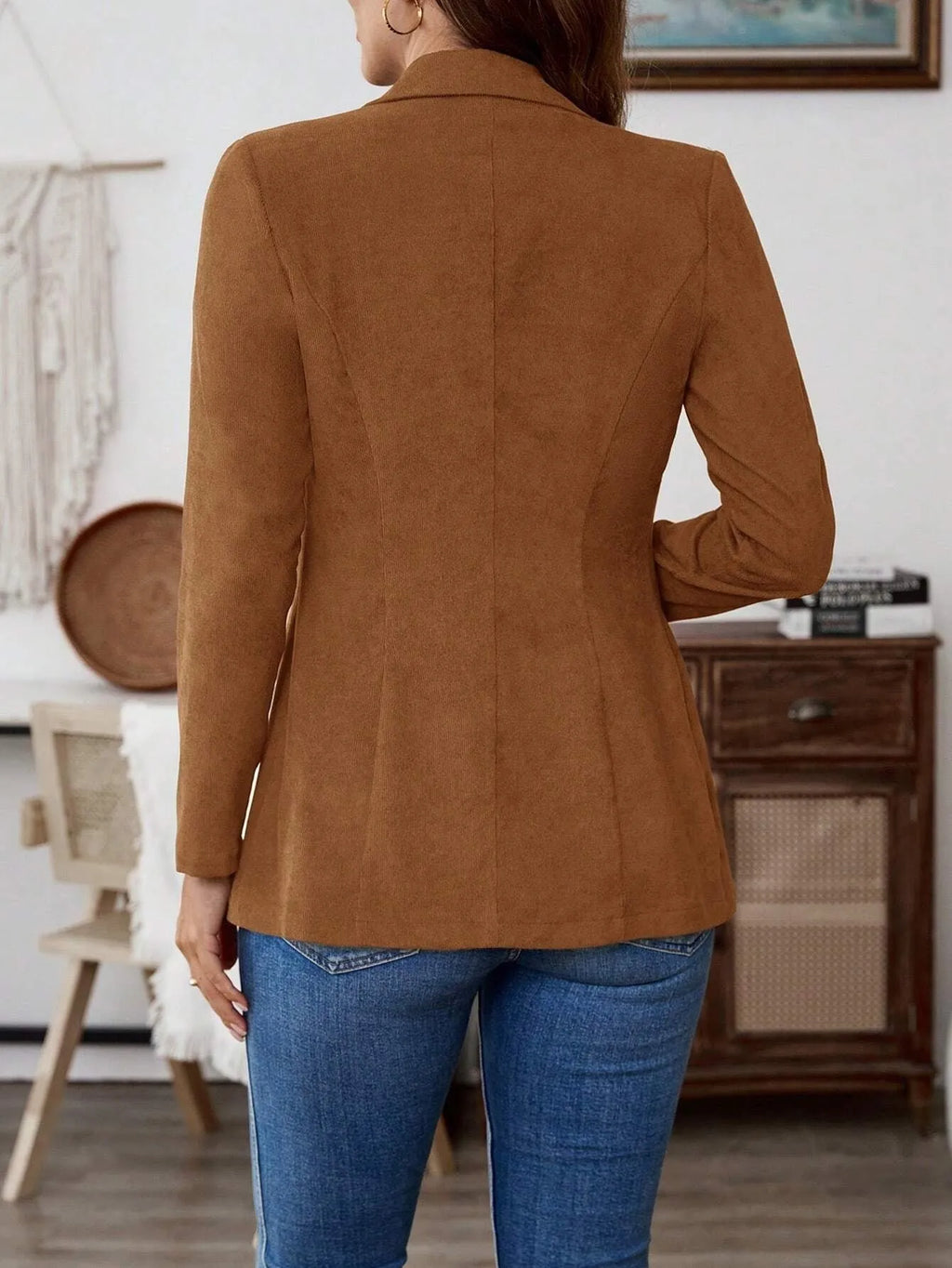 Brown long sleeve single-breasted suit coat with lapel collar on a hanger.